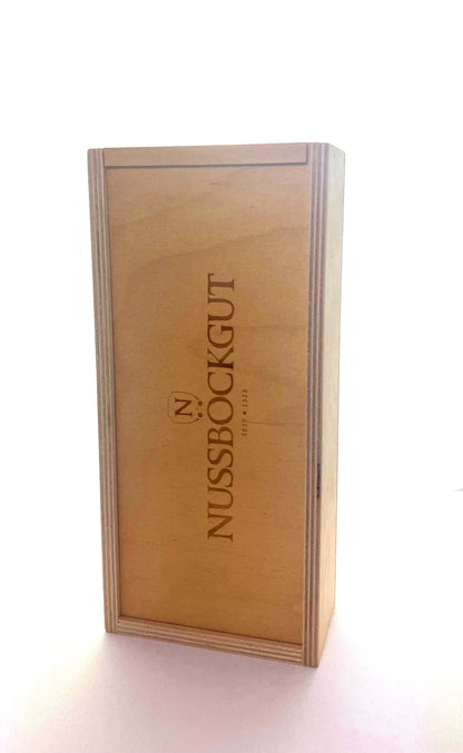 Es ist eine Holzbox für zwei von unseren Essigflaschen abgebildet. Mittig am Schiebedeckel befindet sich das Nussböckgutlogo.