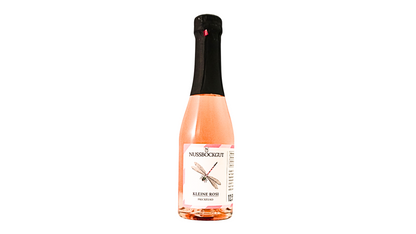 Auf dem Bild ist eine 0,20 l Schaumweinflasche - ein Direktträger als Roseschaumwein - dargestellt. Am Etikett befindet sich der Name des Weingutes - Nussböckgut - der Umriss von OÖ sowie unser Markenzeichen für die Rosemarie, die Libelle, als Nützling des Weingartens.