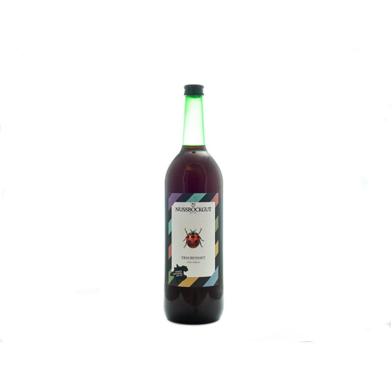 Es ist eine 1 l Traubensaftflasche dargestellt. Am Etikett befindet sich neben dem Nussböckgutlogo ein hübscher Marienkäfer, welcher uns bei der Arbeit im Weingarten stets Freude bereitet.