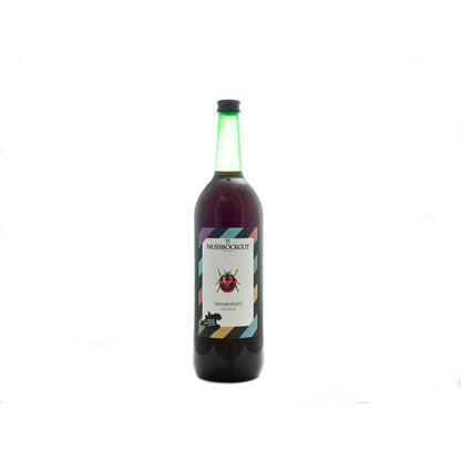 Es ist eine 1 l Traubensaftflasche dargestellt. Am Etikett befindet sich neben dem Nussböckgutlogo ein hübscher Marienkäfer, welcher uns bei der Arbeit im Weingarten stets Freude bereitet.